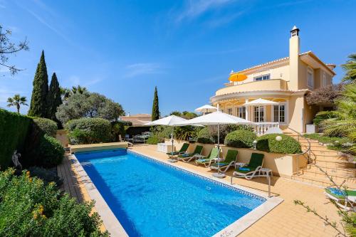a villa with a swimming pool in front of a house at Casa Mandalin in Carvoeiro