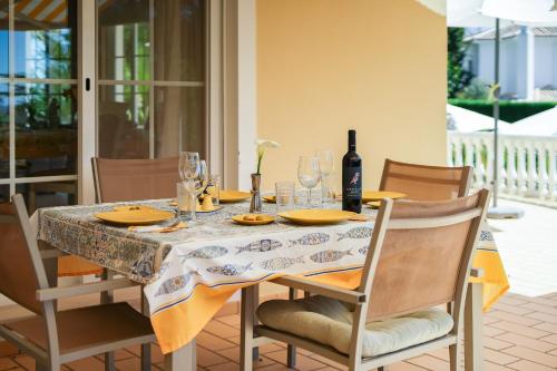 a dining room table with a bottle of wine on it at Casa Mandalin in Carvoeiro