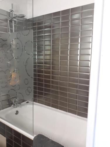 une salle de bain avec baignoire et douche en verre dans l'établissement Bandol Studio, à Bandol