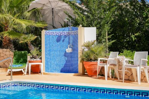 a sign next to a swimming pool with chairs at Casa Mandalin in Carvoeiro