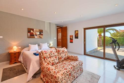 1 dormitorio con cama, sofá y ventana en Teglan, en Jávea