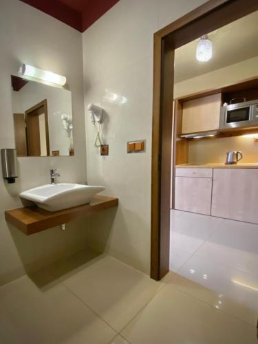 a bathroom with a sink and a mirror at Holiday Resort Tatry in Veľká Lomnica