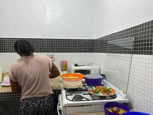 a woman standing in front of a stove in a kitchen at Lui Ushongo Beach House in Pangani