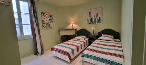 サン・ジャン・ド・リュズにあるBel appartement 3 ch. terrasse parkingの窓付きの客室で、ベッド2台が備わります。