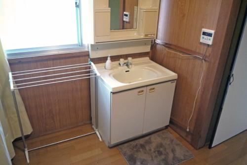 a small bathroom with a sink and a refrigerator at Nikko PRIVATE INN WA NODOKA in Nikko