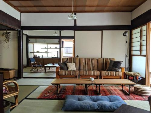 a living room with a couch and a table at 　Komori Village GH ～小森ヴィレッジ ゲストハウス～ 自然の中にある庭付平屋一棟貸 in Obara