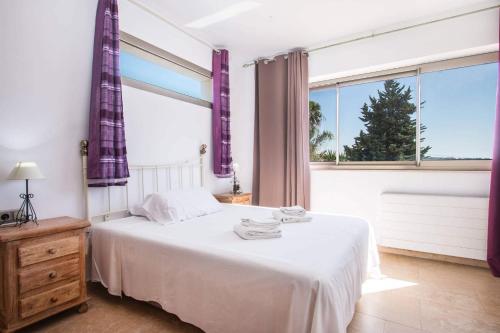 ein Schlafzimmer mit einem weißen Bett und einem großen Fenster in der Unterkunft Villa Athos - PlusHolidays in Calpe