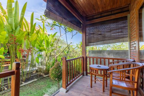 a porch with two chairs and a table on it at D'jineng Rice Terrace Canggu in Canggu