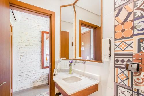 a bathroom with a sink and a mirror at Hotel Villa Lobos Spa Romantik in Extrema