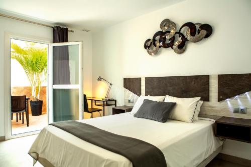 a bedroom with a large bed and a balcony at Apartamentos Aponiente in Conil de la Frontera