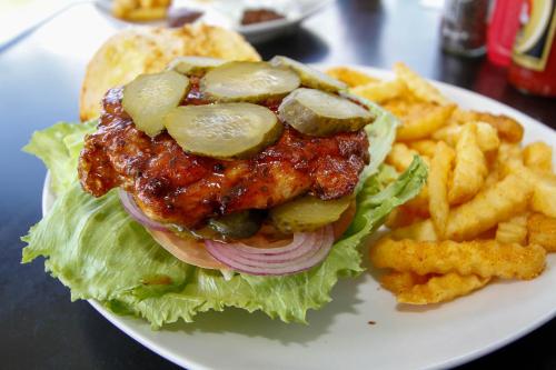 a sandwich with pickles and onions and french fries at SleepOver Orpen Gate in Acornhoek