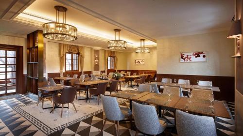 a restaurant with wooden tables and chairs and chandeliers at Lotte Arai Resort in Myoko
