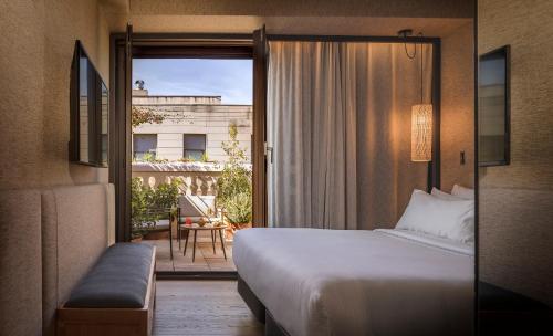Habitación de hotel con cama y balcón en Hotel Casa Sagnier, en Barcelona