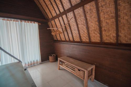a room with a bench and a wooden wall at Selvática in Gili Islands