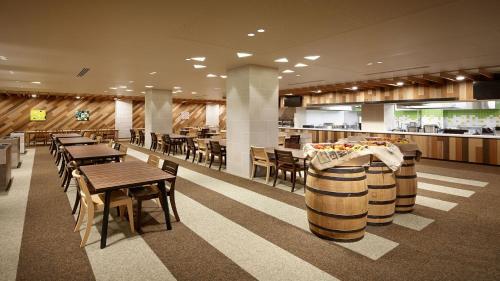 a restaurant with wine barrels and tables and chairs at Lotte Arai Resort in Myoko