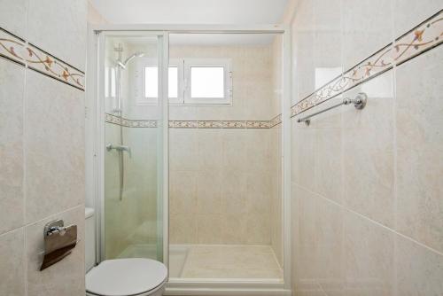 uma casa de banho com um chuveiro e um WC. em Apartamento Arenal 5 - PlusHolidays em Calpe