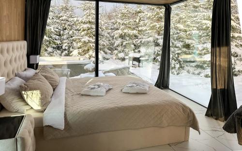 1 dormitorio con 1 cama frente a una ventana grande en 7Mirrors en Murjāņi