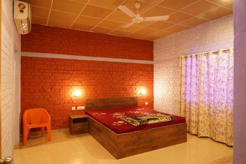 um quarto com uma cama e uma parede de tijolos vermelhos em Brick Field em Varanasi