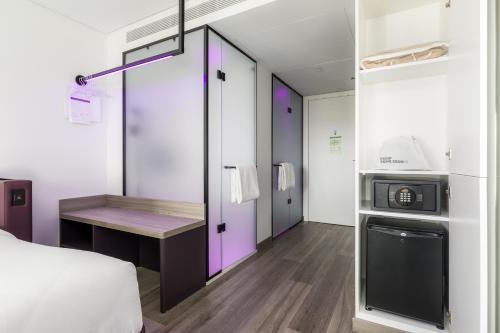 a room with a bed and a desk and a microwave at YOTEL Porto in Porto