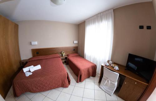 a hotel room with two beds and a television at Country House Elite in Cascia
