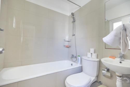 een witte badkamer met een toilet en een wastafel bij Napa Nest in Ayia Napa