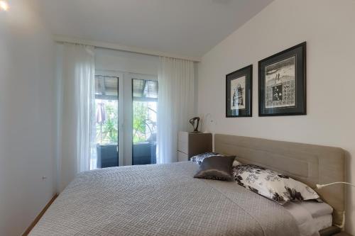 1 dormitorio con cama y ventana en Apartment Palm View II, en Rovinj