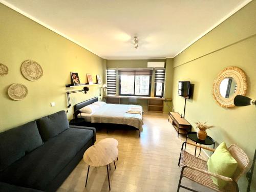 uma sala de estar com um sofá e uma cama em Olive Apartment City Center by thesbnb em Tessalônica