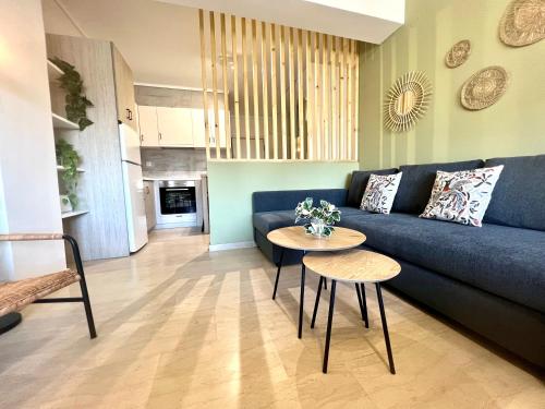 uma sala de estar com um sofá azul e uma mesa em Olive Apartment City Center by thesbnb em Tessalônica