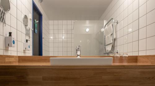 a bathroom with a sink and a mirror at Quality Hotel 11 & Eriksbergshallen in Gothenburg