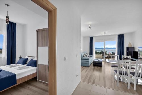ein Schlafzimmer mit einem Bett und ein Wohnzimmer in der Unterkunft Apartments Lujnovic in Makarska