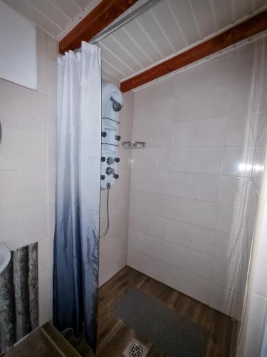 y baño con ducha y cortina de ducha. en Tündérlak Nyaraló Békésszentandrás, en Békésszentandrás