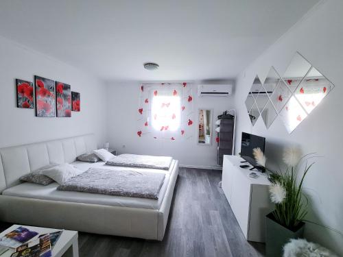 Tündérlak Nyaraló Békésszentandrás في بيكيسزينتاندراس: غرفة نوم بيضاء مع سرير ومكتب