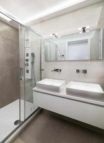 a bathroom with two sinks and a shower at Szikla apartmanok Visegrád in Visegrád