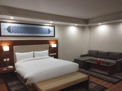 pokój hotelowy z łóżkiem i kanapą w obiekcie Avari Xpress Gilgit w mieście Gilgit