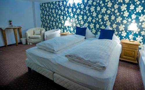 a bedroom with a large bed with blue and white wallpaper at Pensiunea Ghiocelul in Avrig