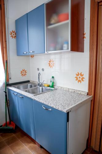 a kitchen with blue cabinets and a sink at Guest House Via Emilia in Marmirolo