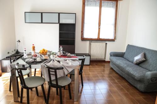 uma sala de estar com uma mesa e um sofá em Guest House Via Emilia 