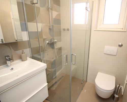 a bathroom with a shower and a toilet and a sink at Apartman Milena in Punat