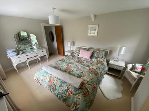 Schlafzimmer mit einem Bett und einem Spiegel in der Unterkunft ‘The Nest’ A beautiful cottage in Devon in Axminster