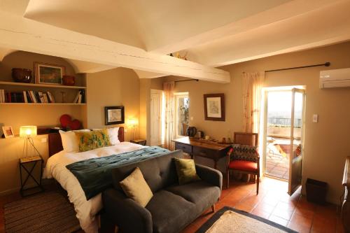 a bedroom with a bed and a couch at La Treille Muscate in Cliousclat