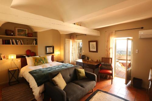um quarto com uma cama e um sofá em La Treille Muscate em Cliousclat