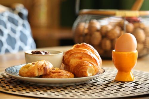 un plato de cruasanes y huevos en una mesa en La Treille Muscate, en Cliousclat