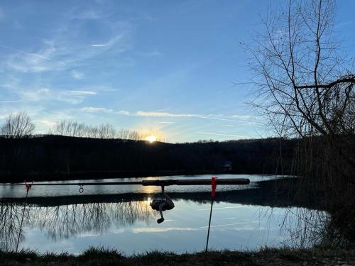 a lake with the reflection of the sun in the water at Dorul Pescarului in Curtea de Argeş