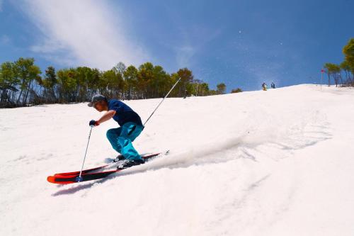 a man is skiing down a snow covered slope at Lotte Arai Resort in Myoko