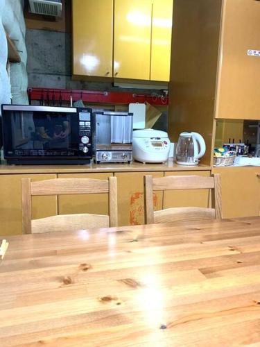 a kitchen with a wooden table and a microwave at Ikebukuro sta. 10mins walk. Rough style 88㎡ House in Tokyo