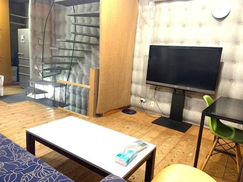 a living room with a flat screen tv on a wall at Ikebukuro sta. 10mins walk. Rough style 88㎡ House in Tokyo