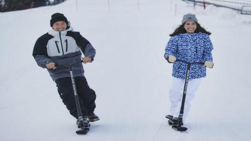 two children are riding on skis in the snow at Lotte Arai Resort in Myoko