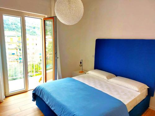 - une chambre avec un lit bleu et une grande fenêtre dans l'établissement Le perle della Costiera, à Sorrente