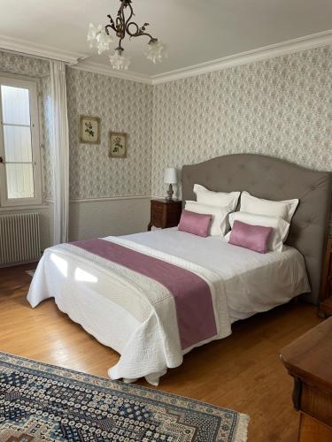 ein Schlafzimmer mit einem großen Bett mit rosa Kissen in der Unterkunft Chateau Du Payre in Cardan