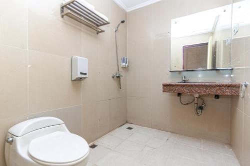 a bathroom with a toilet and a sink and a mirror at RedDoorz Premium at Hotel Ratu Residence in Paalmerah